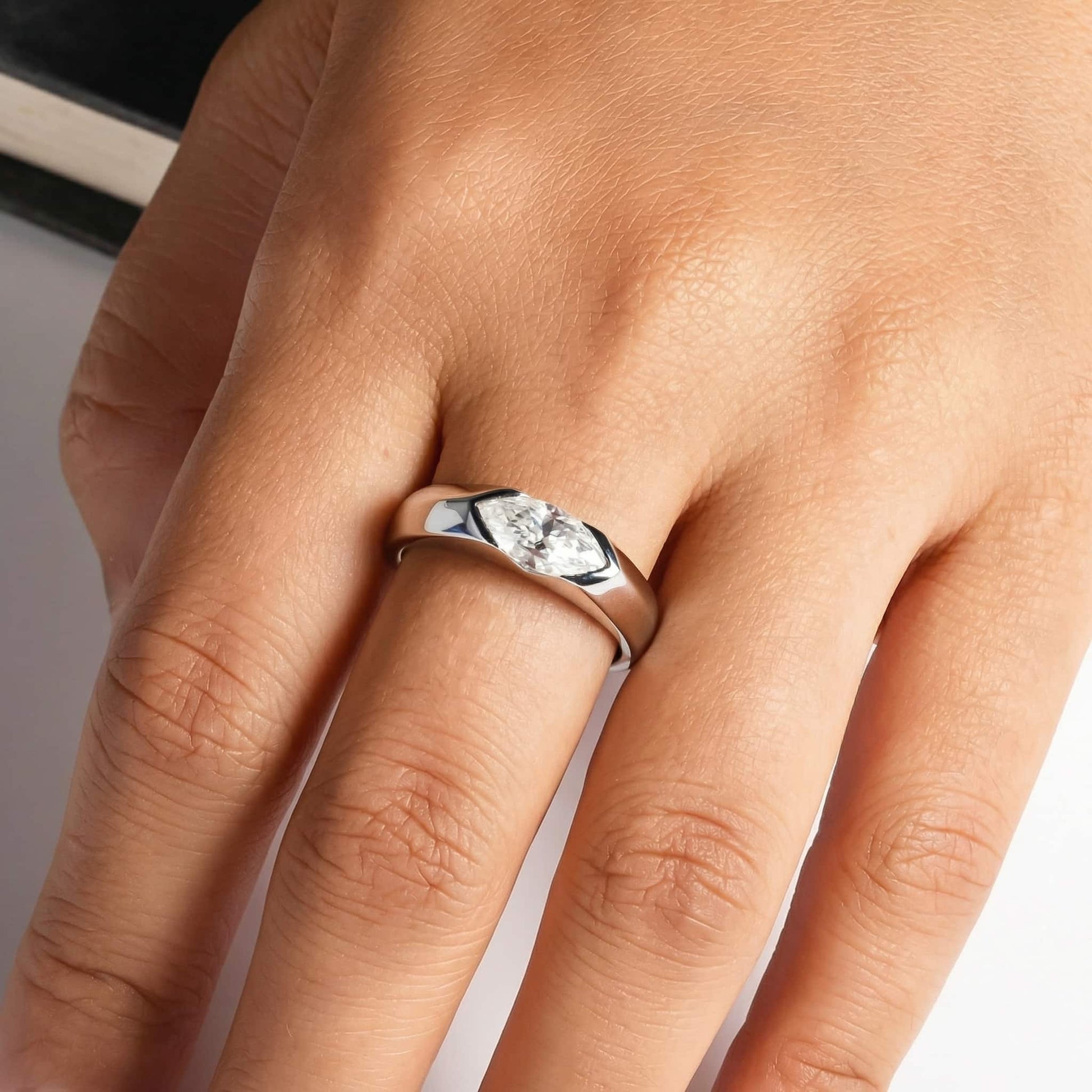 Marquise east-west solitaire platinum-plated ring worn on the finger of a man